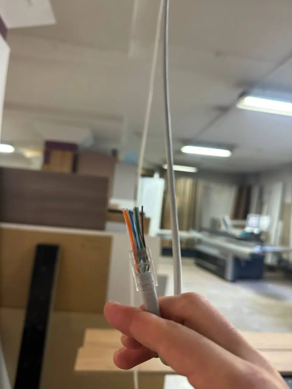 Zarabianie kabla sieciowego na hali produkcyjnej